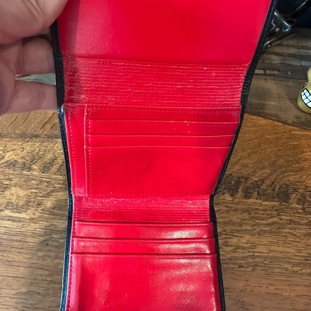 Black leather wallet with a red interior.